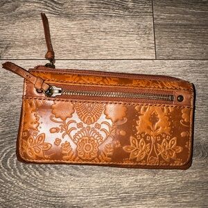 The Sak Iris Leather Zip Wristlet with Floral embossed detail.